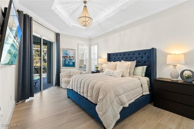 bedroom featuring a tray ceiling, access to outside, multiple windows, and light wood finished floors