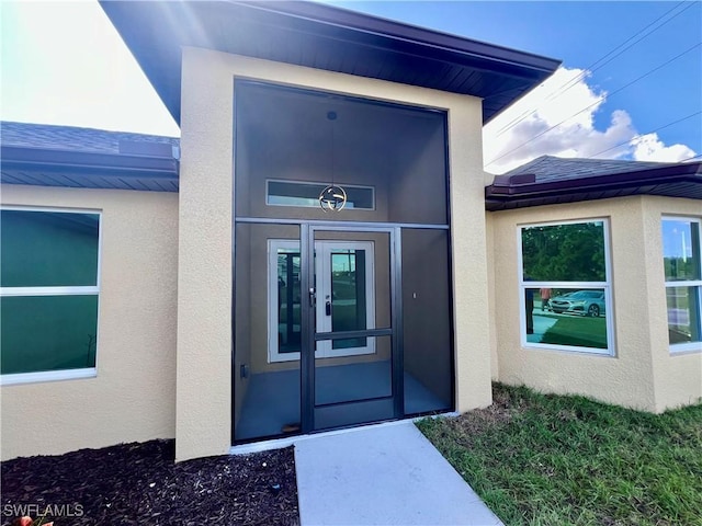 entrance to property featuring french doors and stucco siding