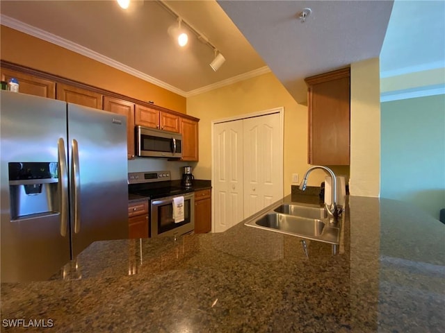 kitchen featuring ornamental molding, brown cabinets, a peninsula, stainless steel appliances, and a sink