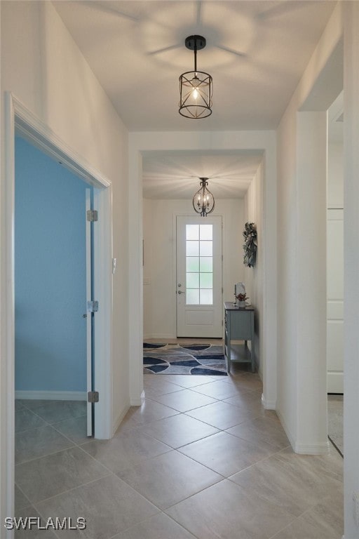 doorway featuring baseboards and light tile patterned flooring