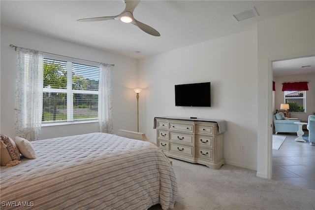 bedroom with ceiling fan, baseboards, and light colored carpet