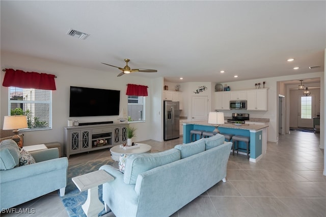 living room featuring a ceiling fan, recessed lighting, visible vents, and light tile patterned floors