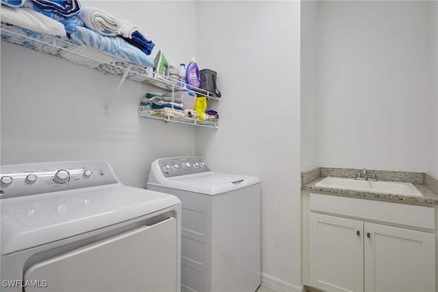 clothes washing area with a sink and washer and dryer