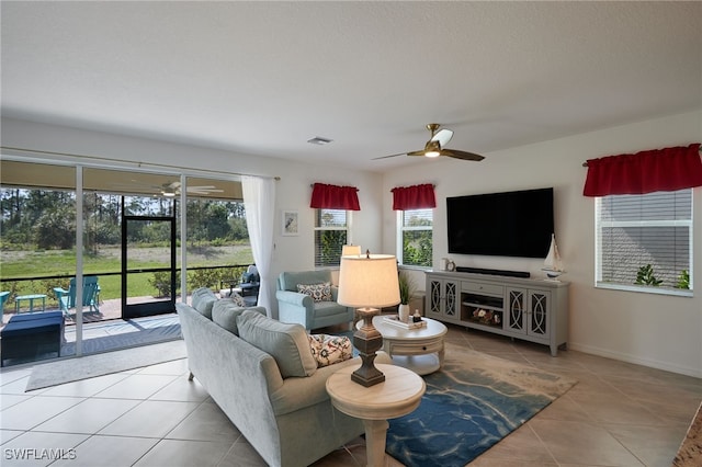 tiled living room featuring baseboards, visible vents, and a ceiling fan