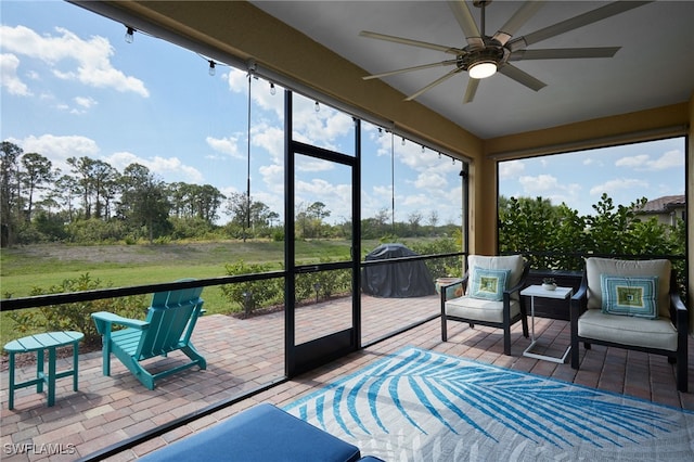 sunroom / solarium featuring ceiling fan