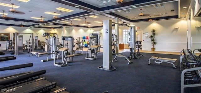 exercise room with baseboards, visible vents, and a drop ceiling