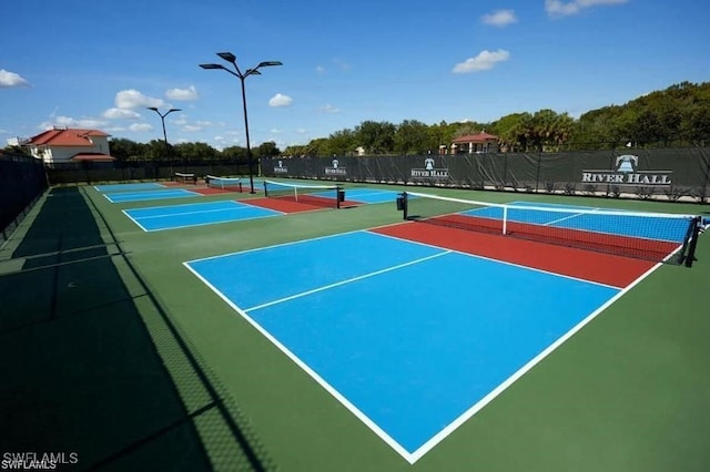 view of tennis court with community basketball court and fence