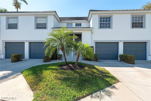 view of front facade featuring concrete driveway, an attached garage, and stucco siding