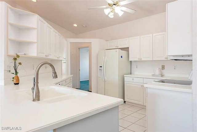 kitchen featuring white fridge with ice dispenser, light tile patterned flooring, a sink, and white cabinetry