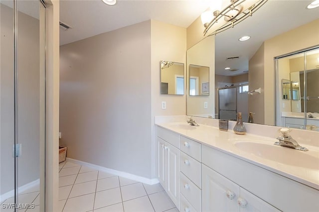 bathroom featuring recessed lighting, a stall shower, a sink, tile patterned flooring, and baseboards