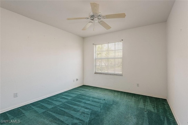 carpeted spare room featuring a ceiling fan and baseboards