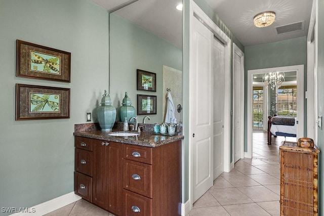 interior space featuring visible vents, vanity, ensuite bath, baseboards, and tile patterned floors