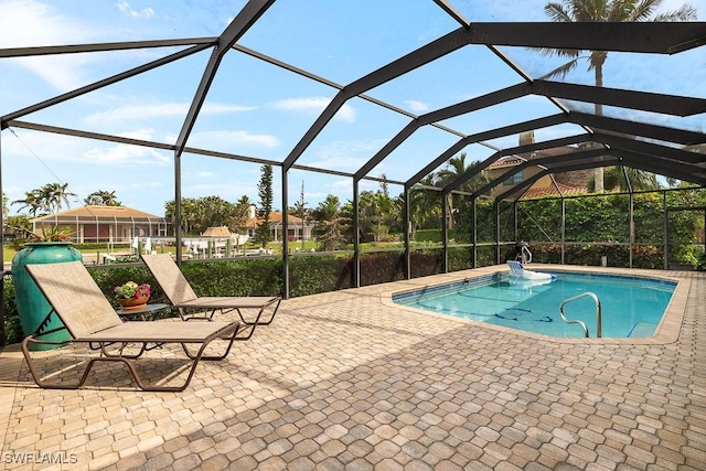 pool with glass enclosure and a patio area