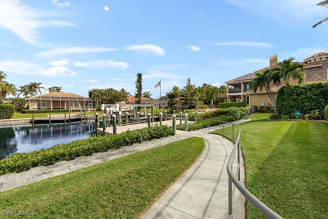 view of property's community featuring a yard, a dock, a water view, and boat lift