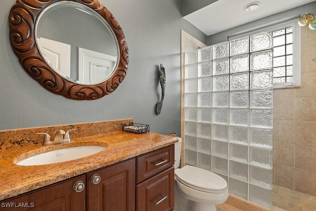 bathroom featuring vanity, toilet, and a walk in shower