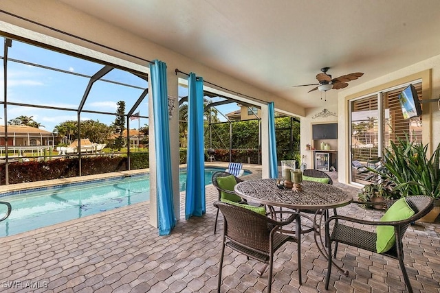 view of patio featuring ceiling fan, outdoor dining space, a lanai, and an outdoor pool