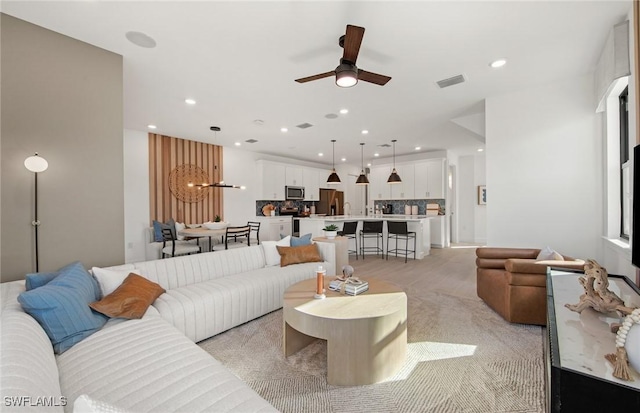 living room featuring visible vents, a ceiling fan, and recessed lighting