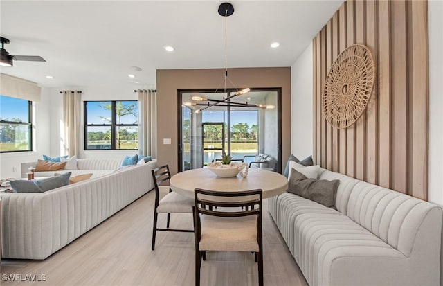 dining space featuring ceiling fan with notable chandelier, light wood-type flooring, and recessed lighting