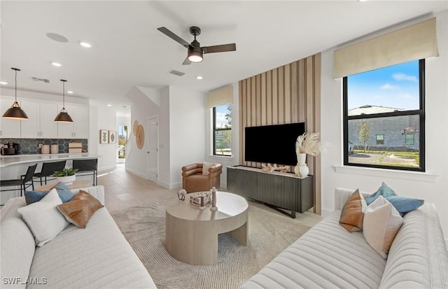 living area with a ceiling fan, recessed lighting, visible vents, and baseboards