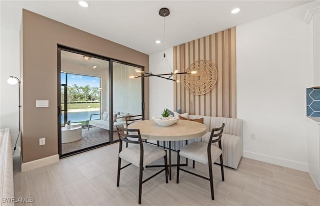 dining area featuring a notable chandelier, an accent wall, recessed lighting, and baseboards