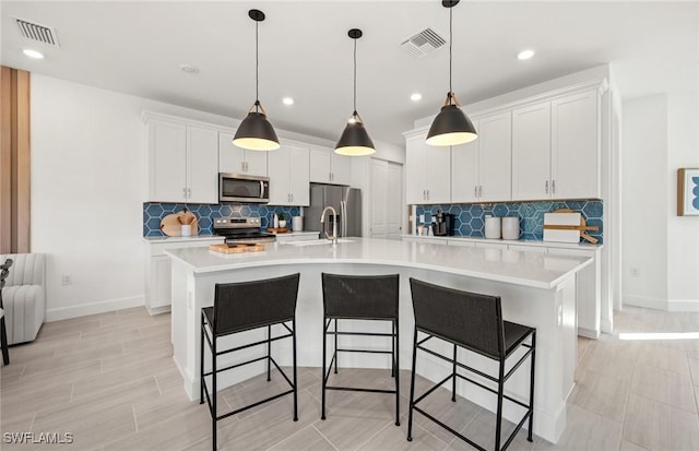 kitchen with stainless steel appliances, light countertops, visible vents, and white cabinetry