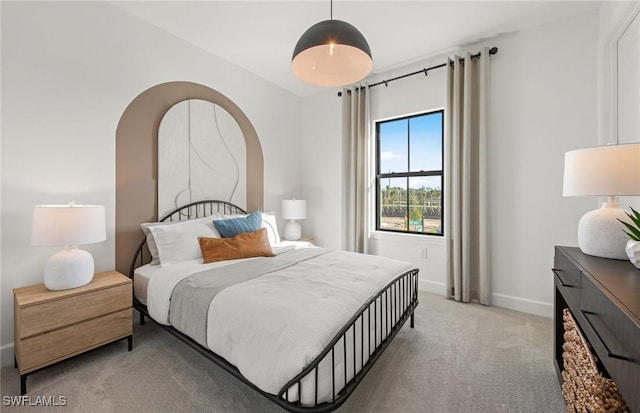 bedroom featuring baseboards and light colored carpet