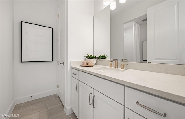 bathroom featuring visible vents, vanity, and baseboards