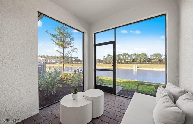 sunroom featuring a water view and a wealth of natural light