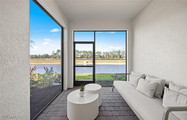 sunroom with plenty of natural light and a water view