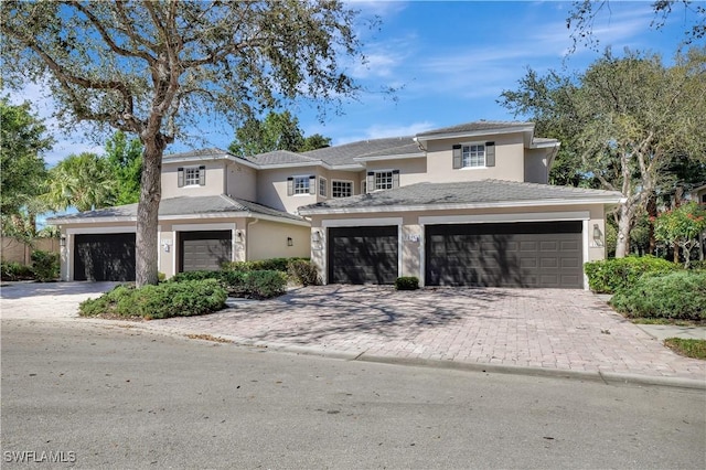 view of front facade with decorative driveway and stucco siding