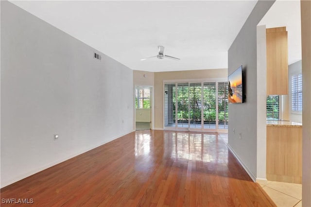 unfurnished room with light wood finished floors, visible vents, baseboards, and ceiling fan