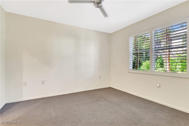 carpeted empty room with baseboards and a ceiling fan