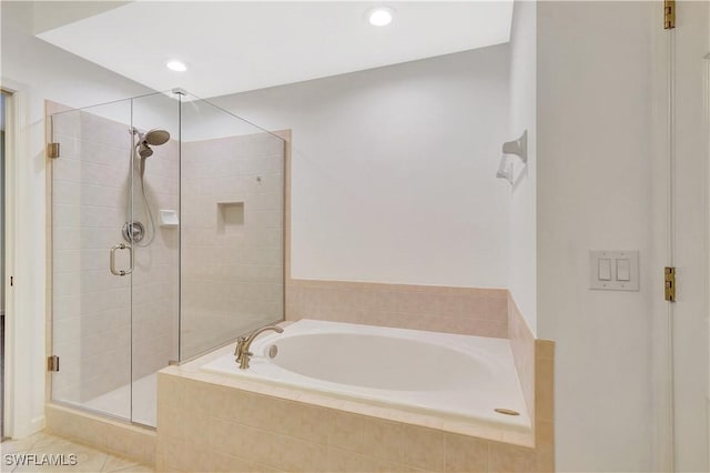 bathroom featuring a bath, recessed lighting, a shower stall, and tile patterned flooring