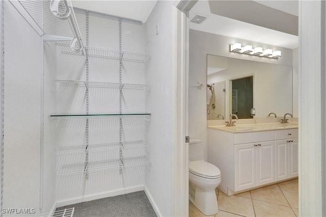 full bathroom with double vanity, toilet, visible vents, and a sink