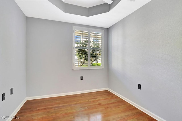 spare room featuring light wood-style flooring and baseboards