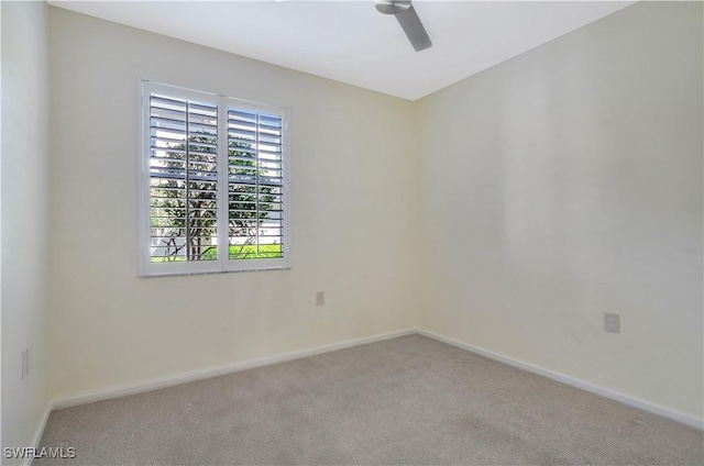 spare room with carpet flooring, a ceiling fan, and baseboards