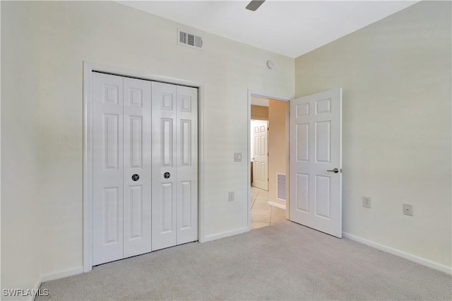 unfurnished bedroom with a closet, visible vents, baseboards, and carpet floors