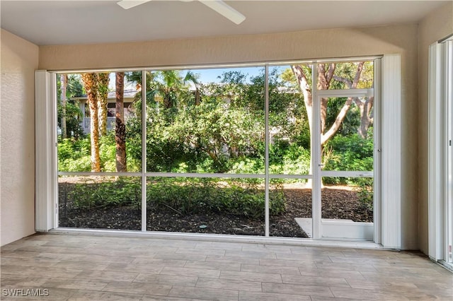 unfurnished sunroom featuring ceiling fan