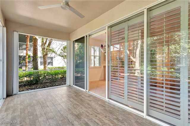 unfurnished sunroom featuring a ceiling fan