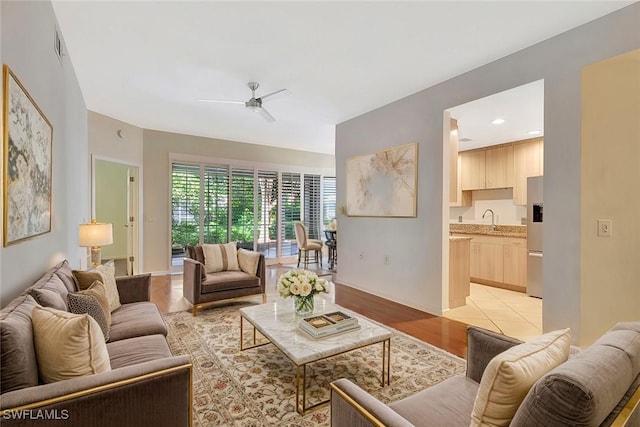 living area with visible vents, ceiling fan, and light wood finished floors