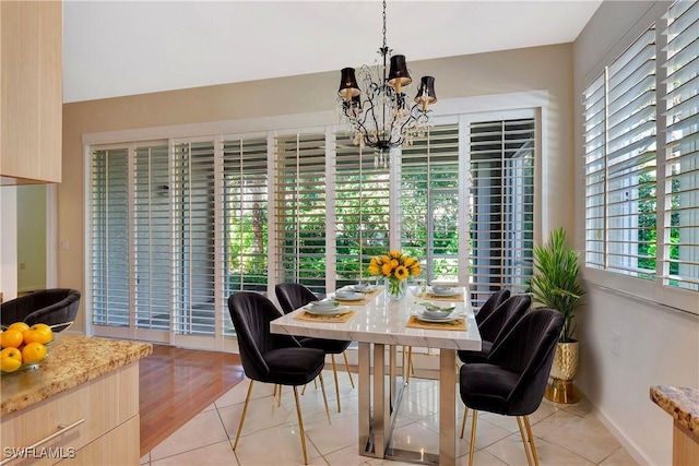 dining room featuring a chandelier and baseboards