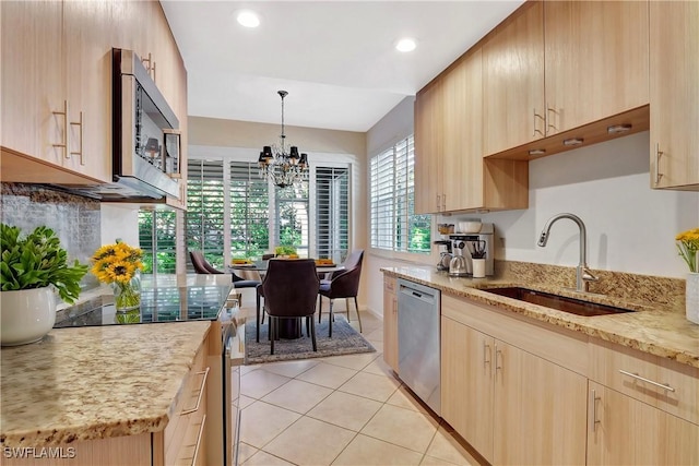 kitchen with a sink, stainless steel appliances, light brown cabinetry, and light tile patterned floors