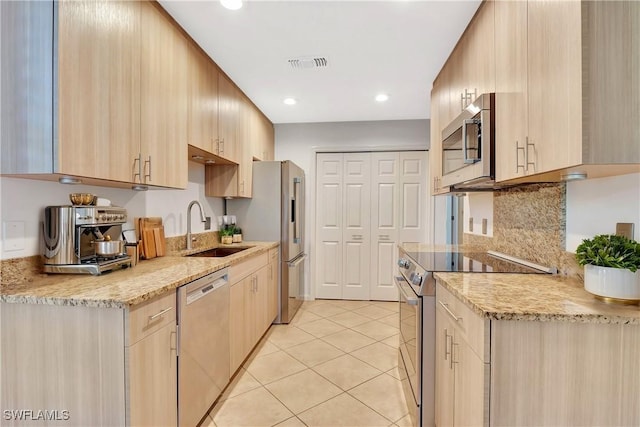 kitchen with visible vents, light brown cabinets, light tile patterned floors, appliances with stainless steel finishes, and a sink