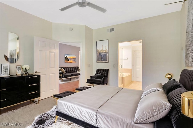 bedroom with visible vents, light colored carpet, ensuite bathroom, and ceiling fan