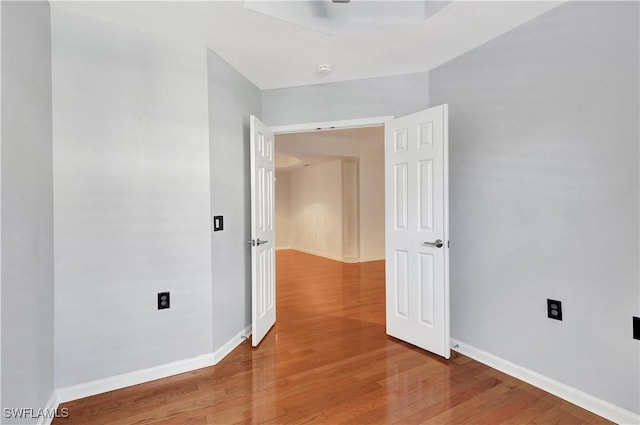 unfurnished room featuring baseboards and wood finished floors