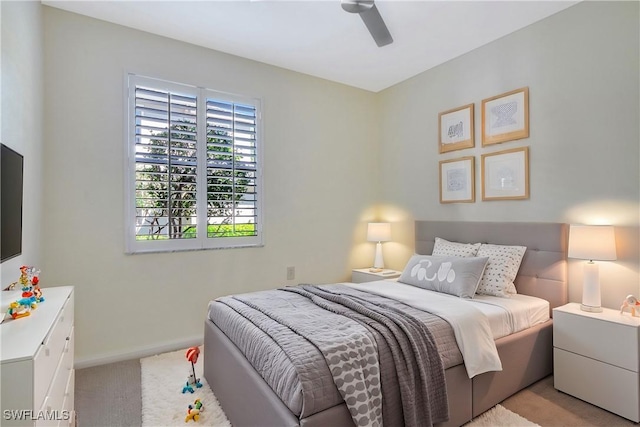 bedroom featuring a ceiling fan, light colored carpet, and baseboards