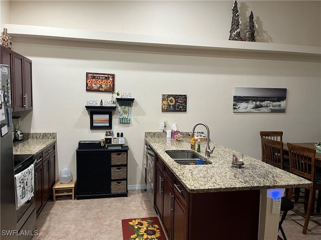 kitchen with dark brown cabinetry, a sink, a peninsula, and a kitchen bar