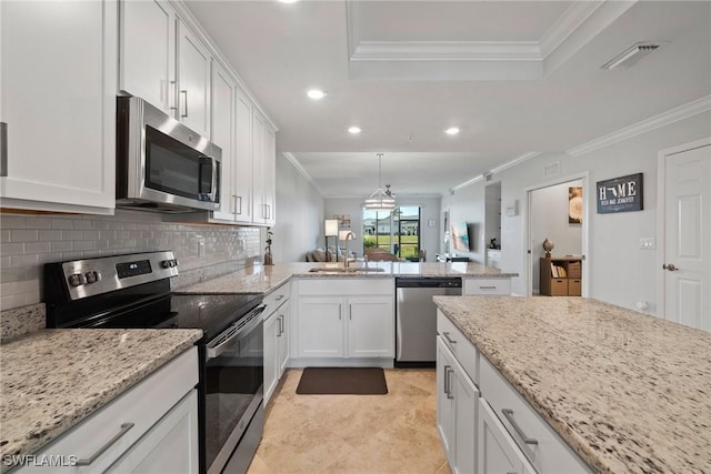 kitchen featuring a sink, open floor plan, ornamental molding, appliances with stainless steel finishes, and tasteful backsplash