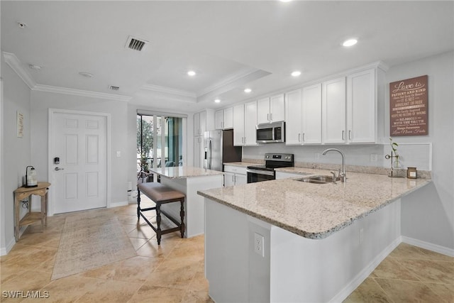 kitchen featuring stainless steel appliances, a breakfast bar, a sink, visible vents, and white cabinets