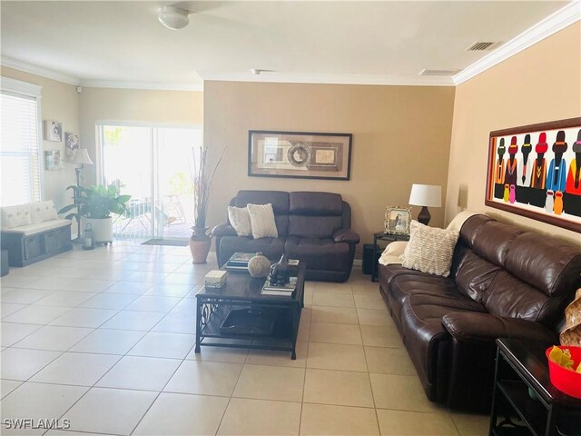 living area featuring light tile patterned floors, ornamental molding, and visible vents